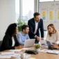 Diverse corporate team collaborating at a conference table in front of an SAP project roadmap whiteboard.