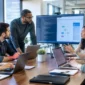 Software development team collaborating on code and UI workflows during an office meeting.
